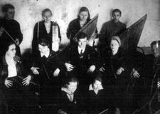 Первый любительский кружок кантелистов, созданный В.П.Гудковым из воспитанников Детского дома и школьников Петрозаводска. Слева,  с дирижерской палочкой в руках, стоит   Виктор Гудков. 1935