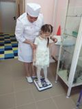 Медицинская сестра Белова Е. И. проводит осмотр ребенка Сабешкиной Арины.