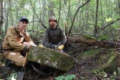 Эксперты проекта - научные сотрудники КарНЦ РАН Александр Кривоноженко и Владимир Карпин рядом с парой жерновов одной из старых мельниц в рамках первой экспедиции. Август, 2024 г.