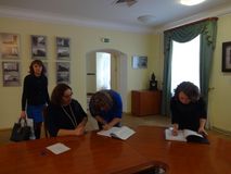 Выпускники расписываются в книге о получении диплома