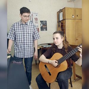 Она берет в руки гитару…